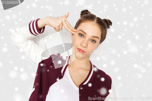 Image of bored teenage girl making finger gun gesture