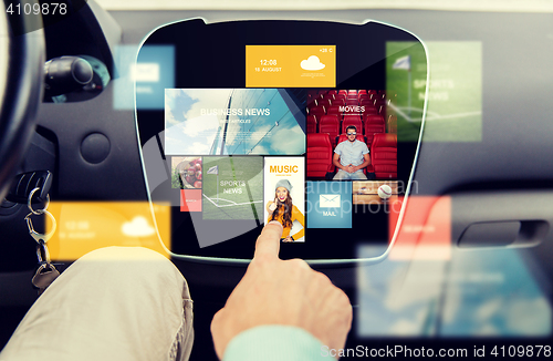 Image of close up of male hand media applications in car