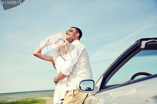 Image of happy couple hugging near cabriolet car at sea