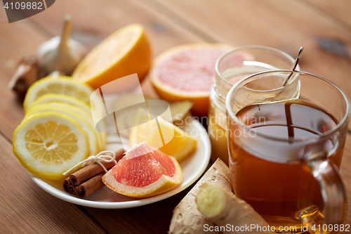 Image of ginger tea with honey, citrus and garlic on wood