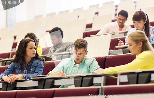 Image of group of students with notebooks in lecture hall