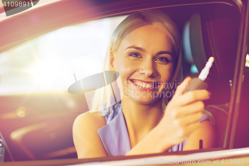 Image of happy woman getting car key in auto show or salon