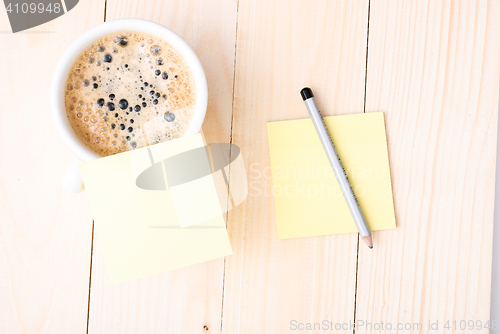 Image of Wood desk with office supplies and cup of coffee