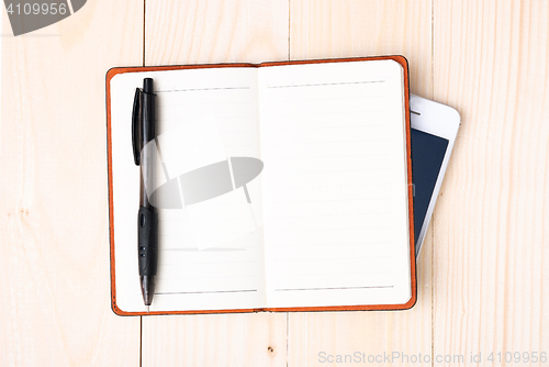 Image of Small notepad with pen and smartphone