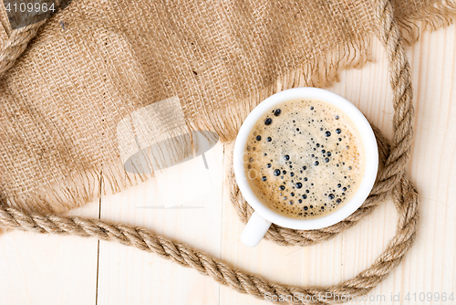 Image of Cup of coffee with foam on wooden table