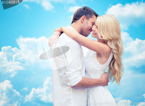 Image of happy couple hugging over blue sky