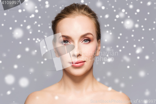 Image of beautiful woman face over gray background and snow