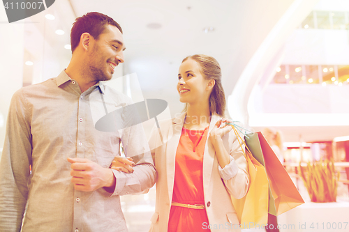 Image of happy young couple with shopping bags in mall