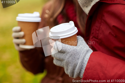 Image of close up of couple hands with coffee in autumn
