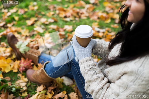 Image of close up of  woman drinking coffee in autumn park