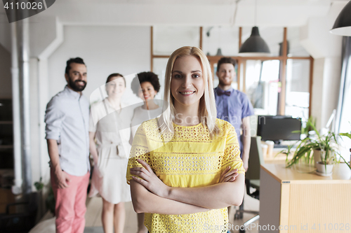 Image of happy young woman over creative team in office