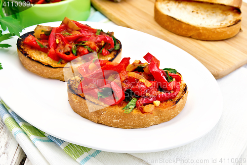 Image of Bruschetta with tomatoes and peppers in plate on board