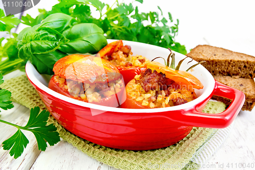 Image of Tomatoes stuffed with bulgur in pan on light board