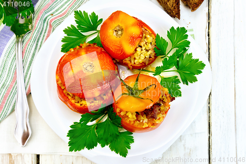 Image of Tomatoes stuffed with bulgur and parsley in plate on board top