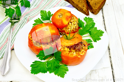 Image of Tomatoes stuffed with bulgur and parsley in plate on table