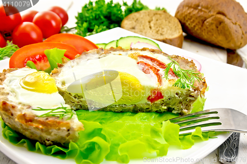 Image of Tartlet meat with egg cut and vegetables on board