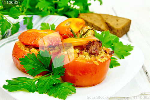 Image of Tomatoes stuffed with bulgur and parsley in plate on board