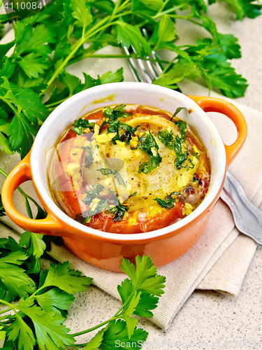 Image of Fish baked with tomato and garlic in red pot on table