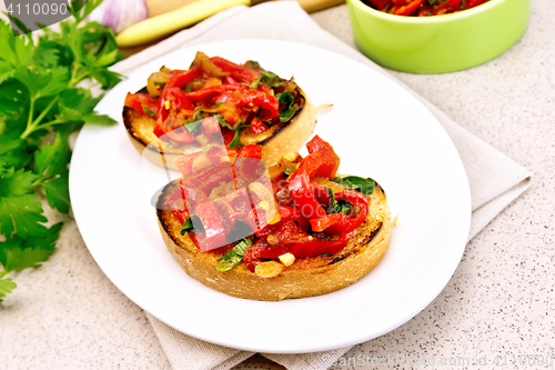 Image of Bruschetta with tomatoes and peppers in plate on granite table