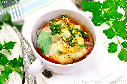 Image of Fish baked with tomato in white bowl on board