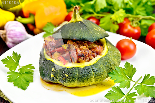 Image of Squash green stuffed with meat and vegetables on dark board