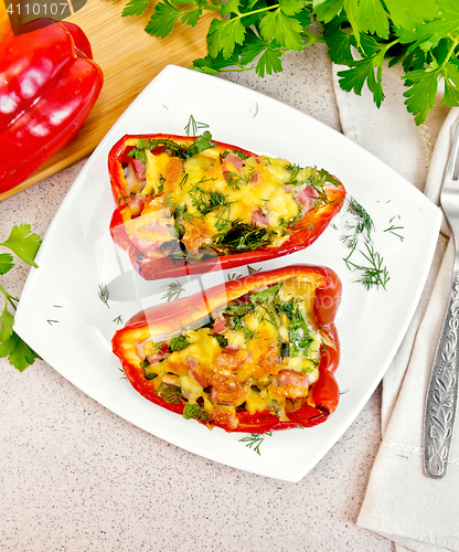 Image of Pepper stuffed with sausage and cheese in plate on table top