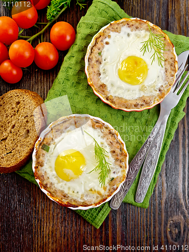 Image of Tartlet meat with egg in pan on board top