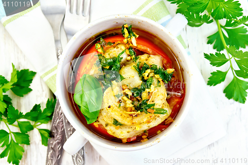 Image of Fish baked with tomato in white bowl on board top