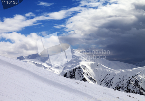 Image of Ski slope in evening and storm clouds