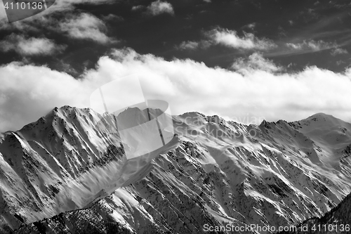 Image of Black and white snow winter mountains and cloud sky in sun eveni