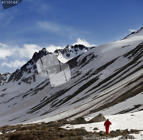 Image of Hiker at snowy mountains in sun evening