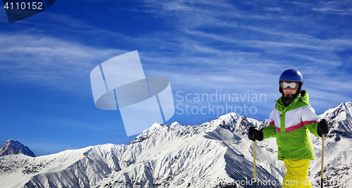 Image of Young skier with on snow mountains at sun winter day