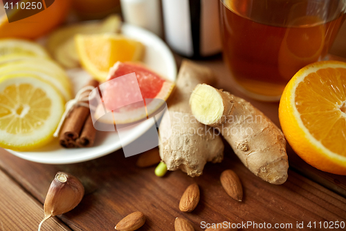 Image of ginger, citrus fruits, tea or honey on wood