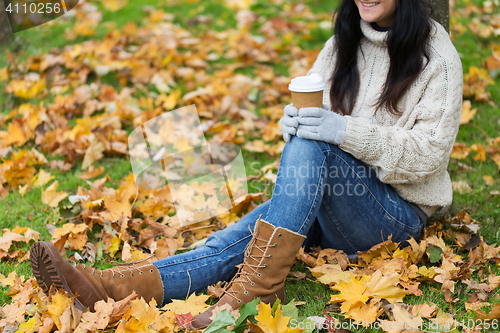 Image of close up of woman drinking coffee in autumn park