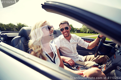 Image of happy man and woman driving in cabriolet car