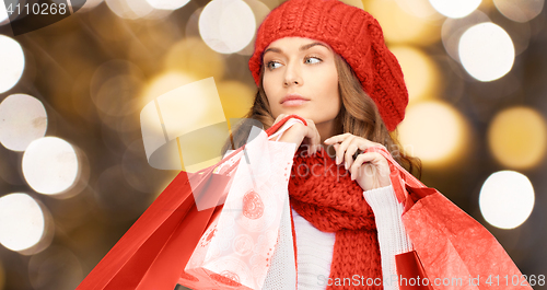 Image of woman in red hat and scarf holding shopping bags