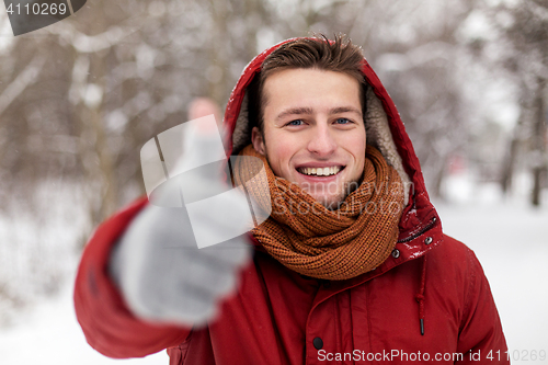 Image of happy man in winter jacket showing thumbs up