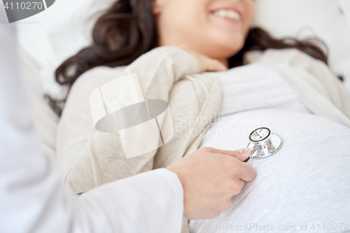 Image of doctor with stethoscope and pregnant woman