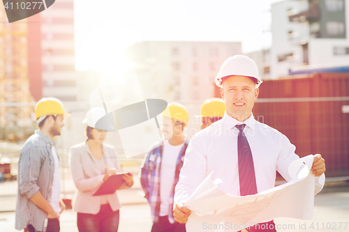 Image of group of builders with tablet pc and blueprint