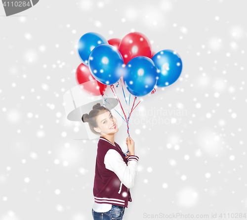 Image of happy teenage girl with helium balloons over snow