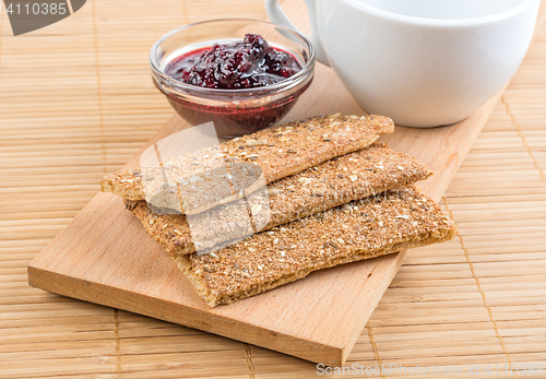 Image of Crispbread and jam. On a wooden stand.