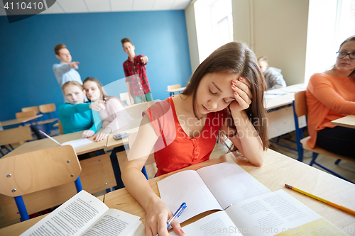 Image of students gossiping behind classmate back at school