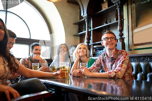 Image of friends with beer watching football at bar or pub