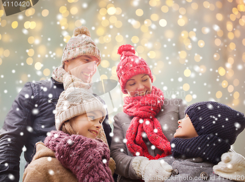 Image of happy family over christmas lights and snow