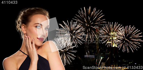 Image of beautiful woman in black over firework lights