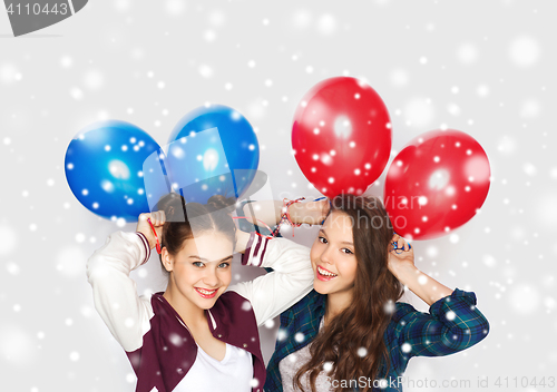 Image of happy teenage girls with helium balloons over snow