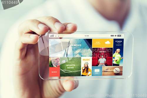 Image of close up of male hand with news on smartphone