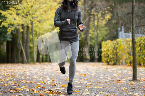 Image of close up of young woman running in autumn park