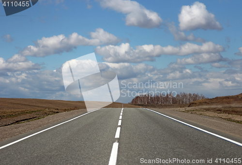 Image of Asphalt road and clouds on blue sky in sunny day