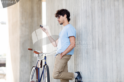 Image of man with smartphone and fixed gear bike on street